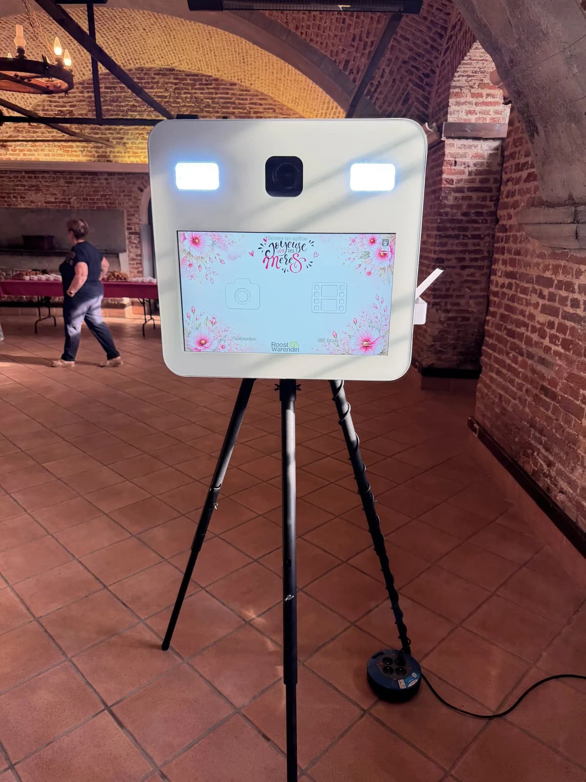 La borne blanche SELPHOTO dans une salle de réception en briques