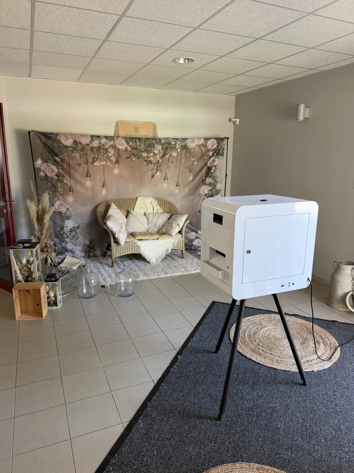 Le photobooth près d’un décor floral et d’un canapé